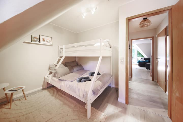 舒适的卧室，配备实用的双层床：楼下有一张大双人床，楼上有一张单人床。 非常适合与家人或朋友入住。 明亮的家具、柔软的地毯和充满爱心的细节营造出轻松舒适的氛围。