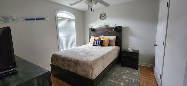 Dormitorio de invitados en la planta superior con cama tamaño queen, TV y vestidor.