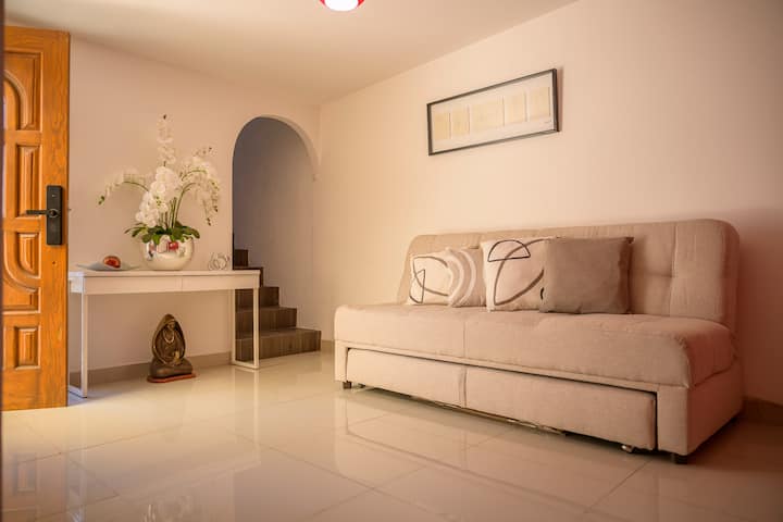✨Bienvenida con estilo✨ Al entrar a "Casa Teresita", te recibe un espacio acogedor con sofá, flores y detalles decorativos, ideal para una primera impresión cálida antes de llegar a la sala principal.