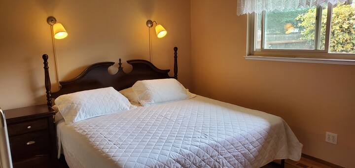 سرير مريح مع أغطية بيضاء ومصباح.