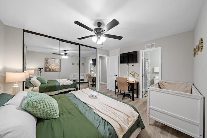 Udobna spavaća soba s bračnim krevetom, krevetićem, prostorom za rad i Smart TV-om.