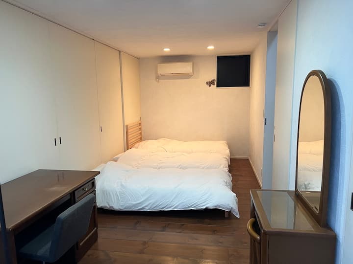 ห้องนอนที่ 1 จากสวนแสง มีโต๊ะ Karimok และตู้ลิ้นชัก
สี่เหลี่ยมสีดำที่มุมของผนังด้านหลังลื่นและหน้าต่าง