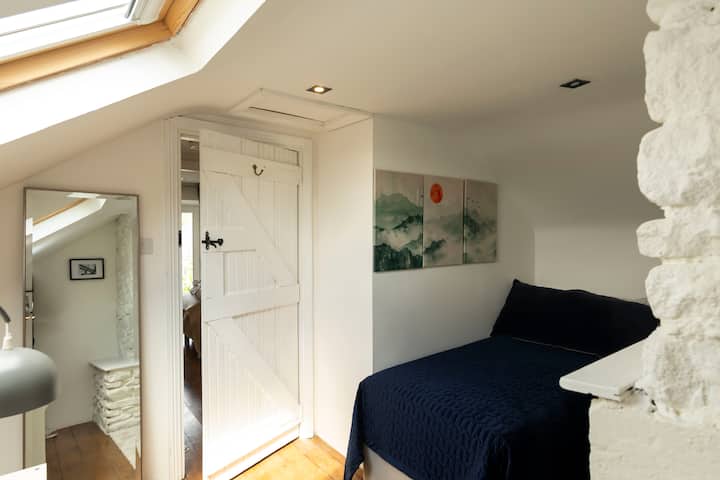 Arriba: cómoda habitación individual con secador de pelo, espacio para colgar la ropa, acceso al baño con ducha y espejo de arriba.