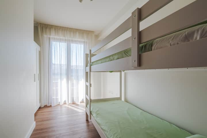 Dormitorio luminoso con litera de tamaño completo, perfecto para niños o amigos en movimiento.