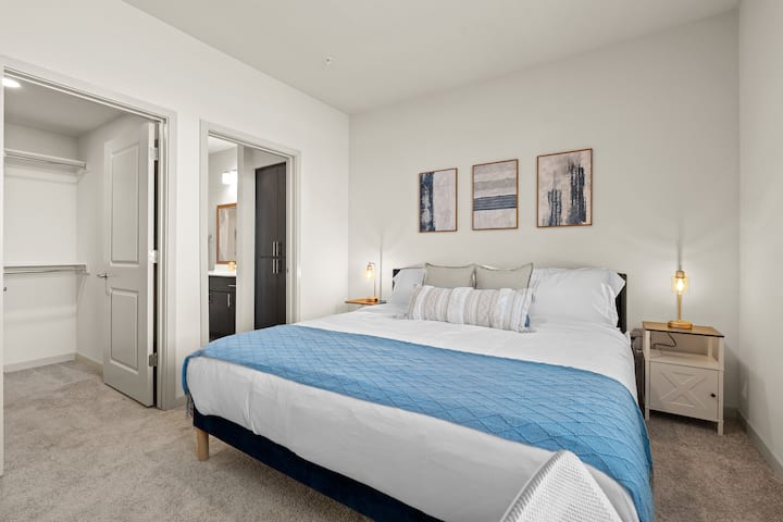 ผ่อนคลายและผ่อนคลายในห้องนอนนี้มีเตียงที่สะดวกสบายพื้นที่ทำงานและพัดลมเพดาน
