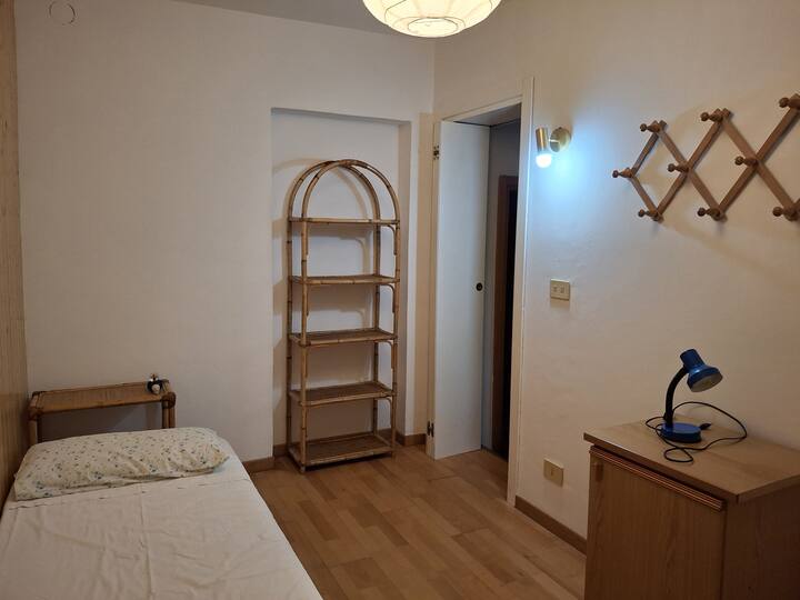 חדר שינה יחיד עם חלון המשקיף על הגינה.