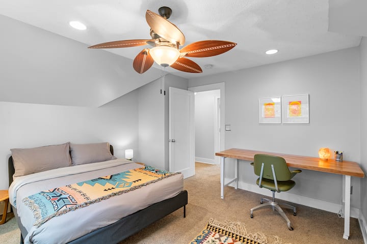 غرفة نوم في الطابق الثاني مع سرير بحجم متوسط ومكتب. 