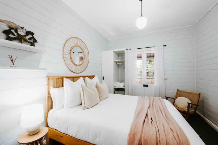 Springe in das Queensize-Bett von Schlafzimmer drei, um einen erholsamen Schlaf zu genießen. Es bietet direkten Zugang ins Freie und Stauraum für deine Sachen.