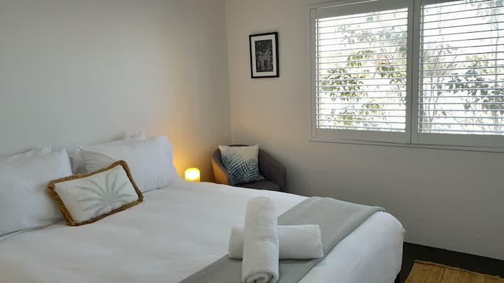 Este segundo dormitorio queen con vistas frondosas para un ambiente costero relajado. Un montón de espacio de almacenamiento con batas incorporadas.