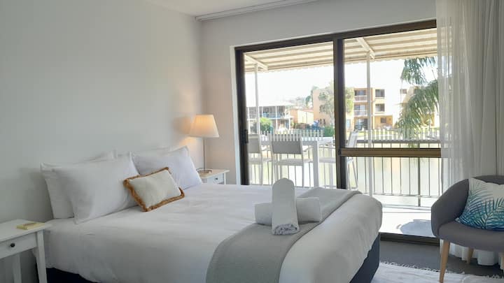 Despiértate con una suave luz natural y sal directamente al balcón desde este sereno refugio principal con cama tamaño queen. Almacenamiento de batas incorporado.