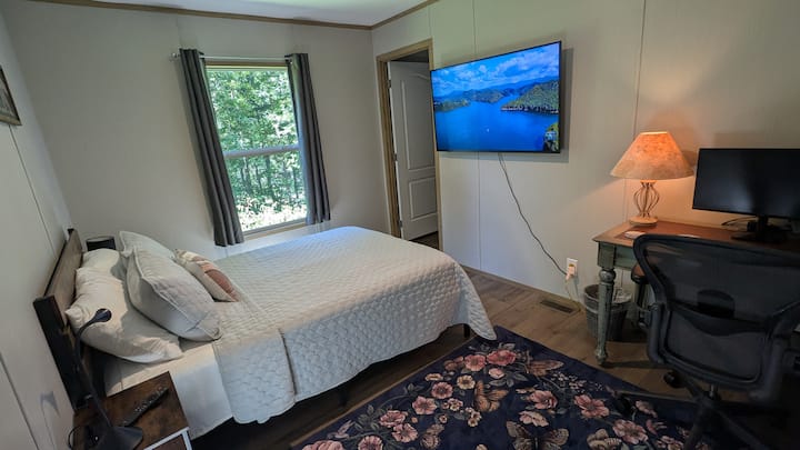 Bedroom 3 has a full bed, dedicated workspace, and 55" TV