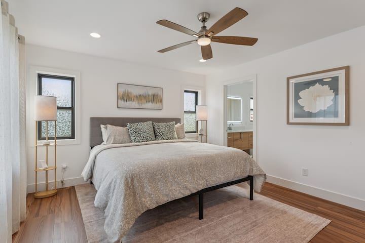 La chambre à coucher principale offre un lit confortable parfait pour une nuit de sommeil reposante, une commode, un miroir pleine longueur, un chargeur sans fil et un réveil. Elle comprend également une salle de bain attenante pour plus d'intimité et offre une vue imprenable sur le lac.