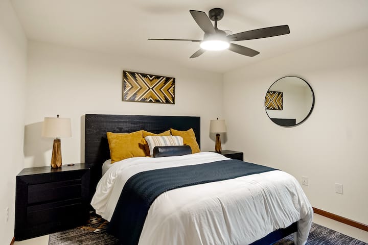 带标准双人床、智能电视和步入式衣柜的地下室卧室。 