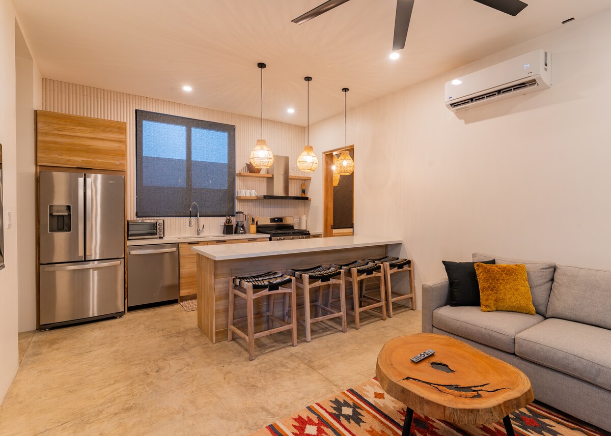 Sala de estar Casita Backdoor: un espacio luminoso y aireado con abundante luz natural, con sofá cama y TV. El lugar perfecto para relajarte y recargar energías después de una sesión de surf.