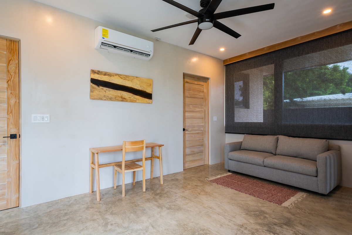 Salón en la planta superior
En la parte superior de las escaleras, un espacio versátil con un escritorio, aire acondicionado y un sofá que se convierte en una cama tamaño queen, ideal para trabajar a distancia, estudiar o dormir.