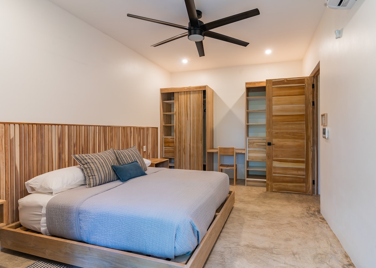 Dormitorio principal de Casita Backdoor
Configurada con una cama tamaño king o dos camas individuales XL, esta suite cuenta con aire acondicionado, dos armarios y acceso a una terraza privada, un refugio cómodo para descansar después de tus aventuras en Nosara.