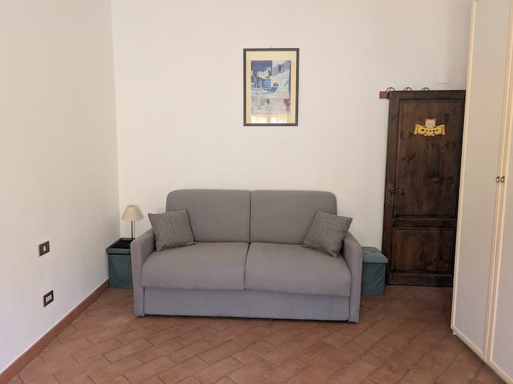 Elegantná druhá izba s terakotovou podlahou a pohodlnou rozkladacou pohovkou vo francúzskom štýle. Ideálne miesto na spánok alebo relax, ktoré ponúka útulný kútik pre tých, ktorí cestujú v skupine alebo rodine.