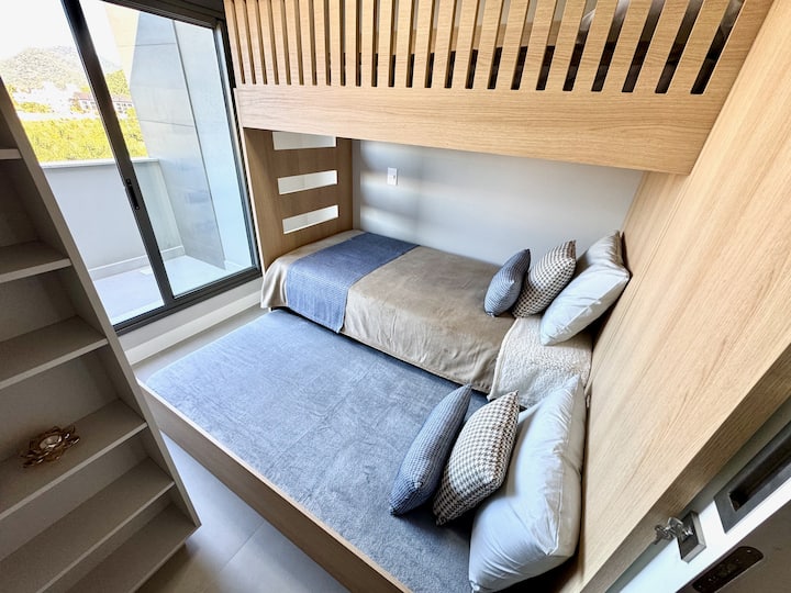 Dortoir, situé à l'étage supérieur. Elle dispose d'un lit superposé et d'un lit d'appoint, qui est sous le lit superposé, d'un petit ventilateur de plafond, d'une armoire et d'un volet motorisé. Accès au deuxième balcon, qui couvre les 2 chambres.