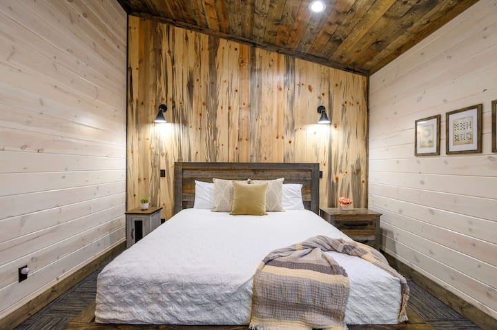 Cozy wood-accented cabin bedroom with soft textures, warm lighting, and rustic charm.