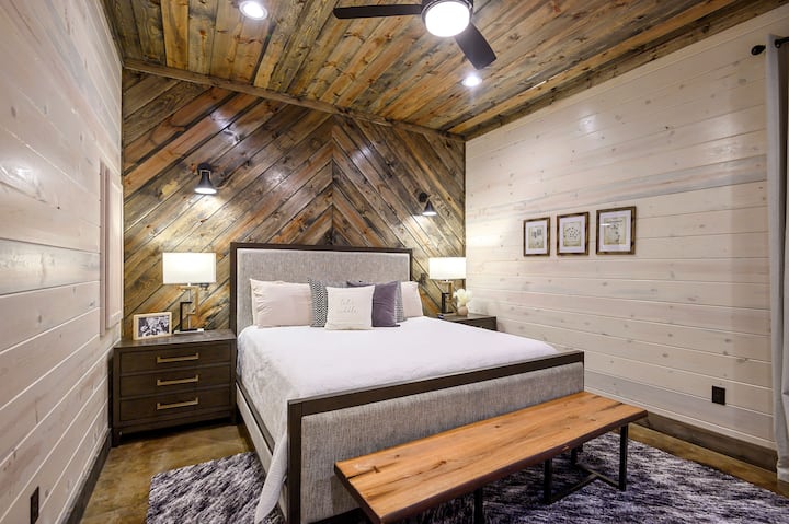 Chevron accent bedroom with gray headboard, wooden nightstands & lamps for cozy ambiance.