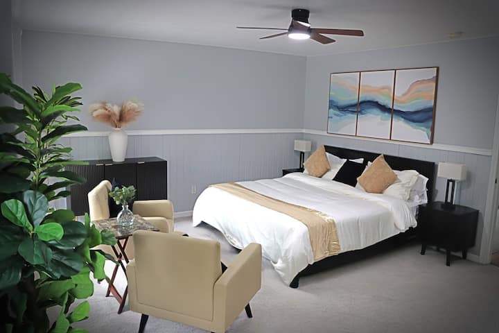 Espacioso refugio con cama tamaño king: relájate en una habitación luminosa y espaciosa con una lujosa cama tamaño king, cómodas sillas de salón y una exuberante vegetación. Un espacio tranquilo para recargar energías o disfrutar del café de la mañana junto a la ventana.