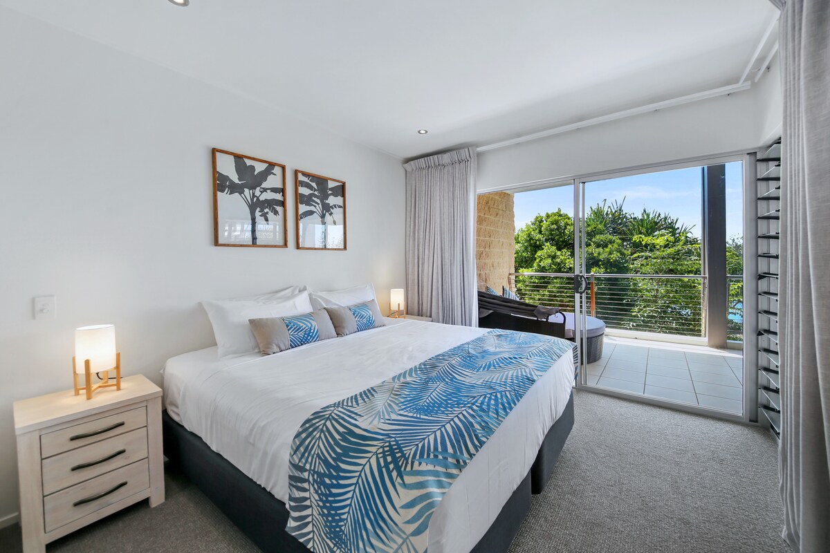 חדר שינה ראשי מרווח וממוזג עם נוף ללגונה. 