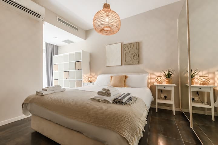Elegante y luminoso dormitorio doble con cama tamaño queen, ropa de cama de calidad y diseño moderno. El lugar perfecto para relajarse y descansar después de un día explorando Malta.