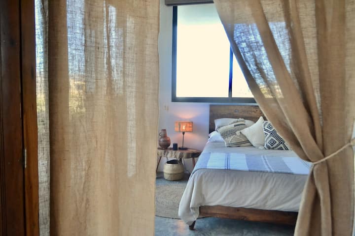 Apartmán Dune Level Double Queen s veľkými posuvnými sklenenými dverami, ktoré sa otvárajú na krásnu terasu s výhľadom na púštne hory.