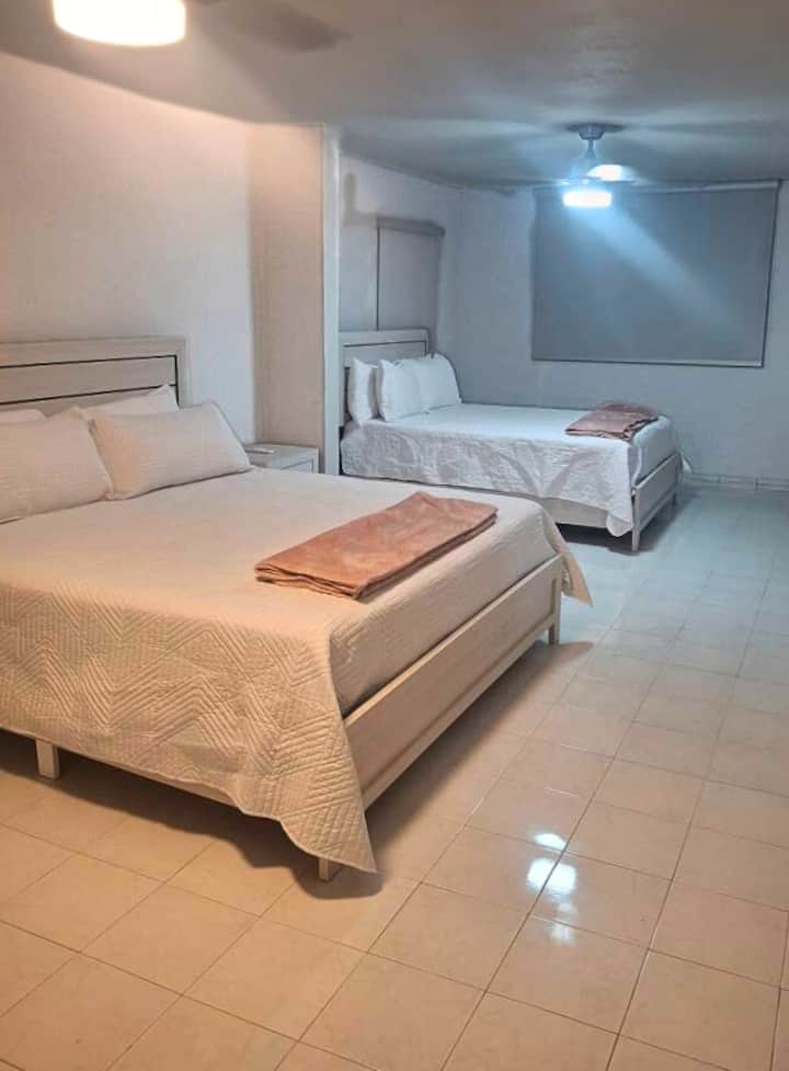 Suite principal en la planta alta con una cama tamaño king, una cama tamaño queen y un baño privado para mayor comodidad.