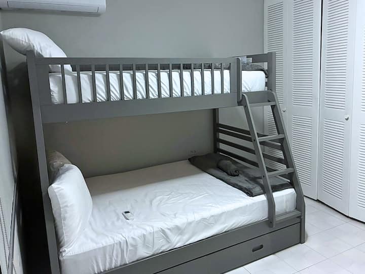 Habitación luminosa y cómoda con una litera doble con espacio en el armario, perfecta para niños, amigos o familias pequeñas.