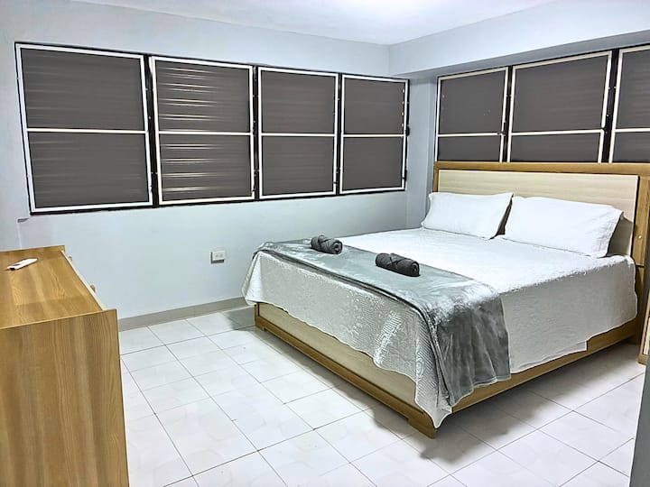 Amplio y luminoso dormitorio principal en la planta baja. Cama tamaño queen, sábanas frescas, persianas opacas, diseño moderno y limpio y un mini-split para mayor comodidad.