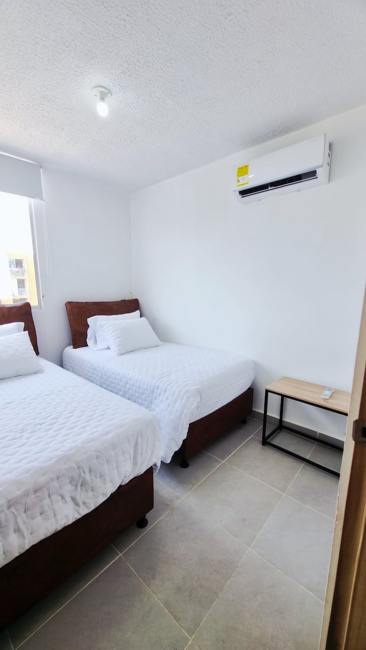Amplia y luminosa habitación con dos camas dobles sencillas, diseñada con un estilo moderno y detalles elegantes para garantizar descanso, confort y privacidad. Ideal para familias o grupos que buscan comodidad en un ambiente sofisticado.