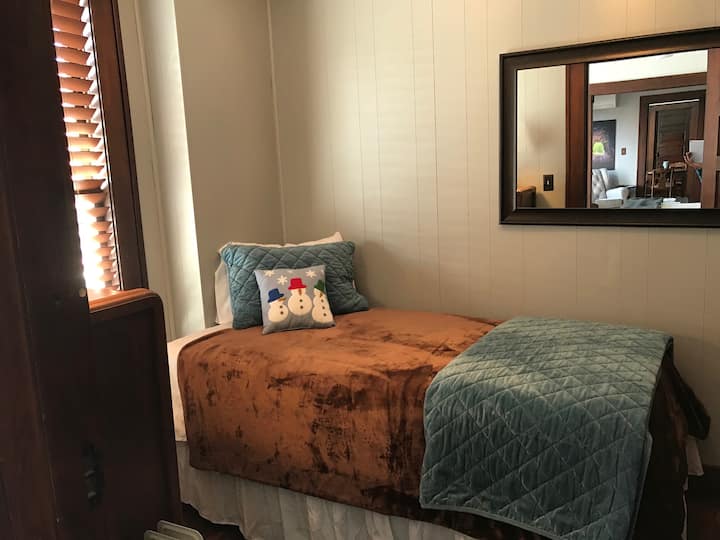 Съблекалня с две легла, скрин и закачалка за дрехи.