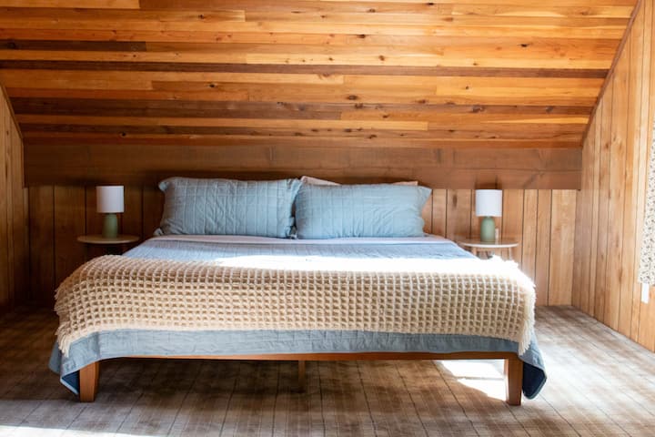 La suite principal en el segundo piso ofrece una cómoda cama tamaño king.