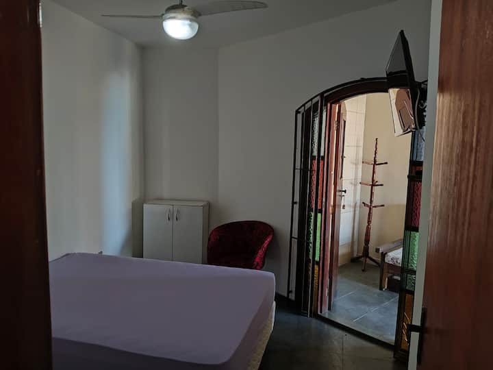 חדר שינה עם טלוויזיה חכמה ומאוורר תקרה.