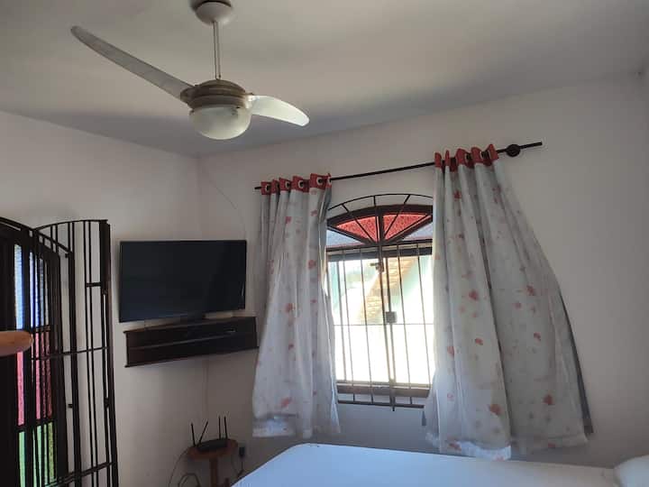 חדר שינה עם טלוויזיה חכמה ומאוורר תקרה.