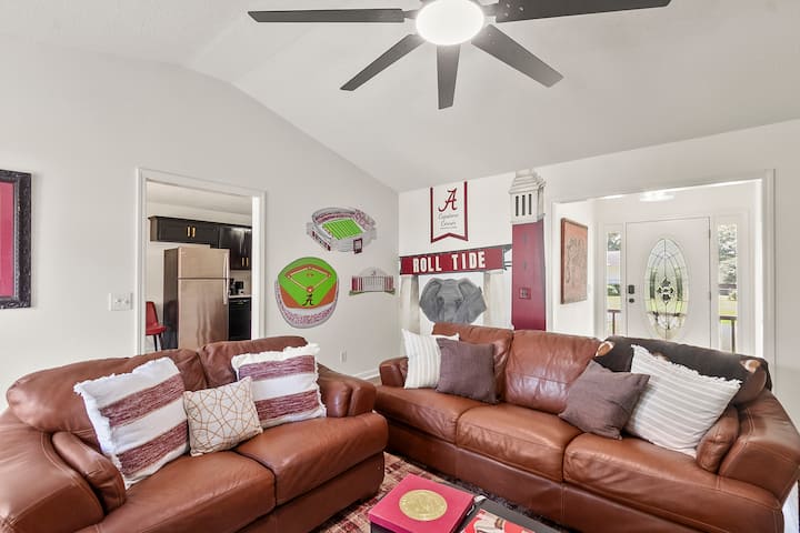 อยากมีพื้นที่สบายๆ ให้ดูเกมไหม? ห้องนี้มีทุกอย่าง พัดลมเพดานขนาด 72 นิ้ว การเข้าถึงดาดฟ้าด้านหลัง โซฟาหนัง หนังสืออ่านเล่นจากอลาบามา จิตรกรรมฝาผนังสำหรับภาพถ่ายกลุ่ม 