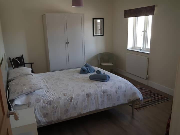 Спална соба на приземје со брачен кревет, гардеробер и масичка за облекување