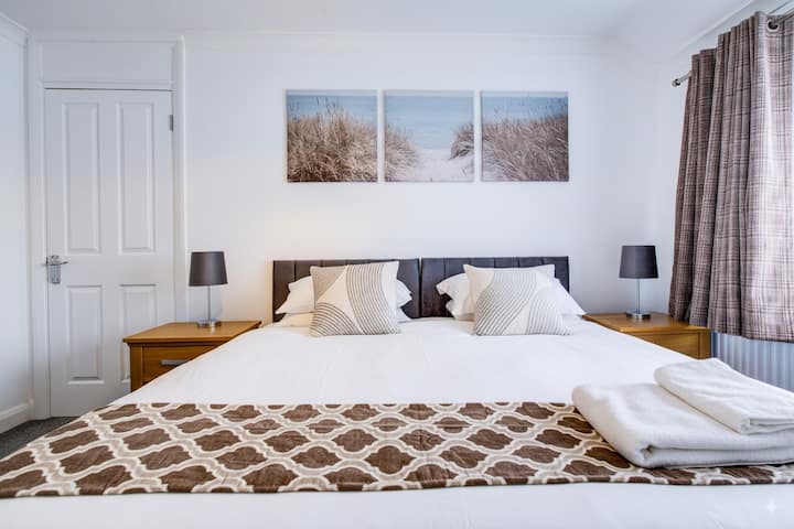 Тази спалня има легло с цип, което се превръща в 2 единични, ако е необходимо, или в супер голямо двойно легло, ако предпочитате тази опция. По подразбиране е супер голямо двойно легло. Имаме и разтегателен диван в същата стая, ако желаете.