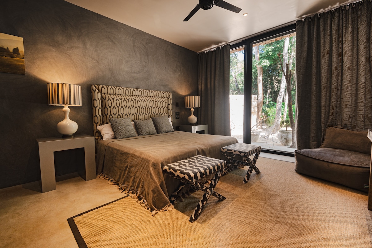 This serene suite offers full privacy and rest, with black curtains for uninterrupted sleep and floor-to-ceiling windows that open to the jungle—blending comfort and calm in perfect balance.

