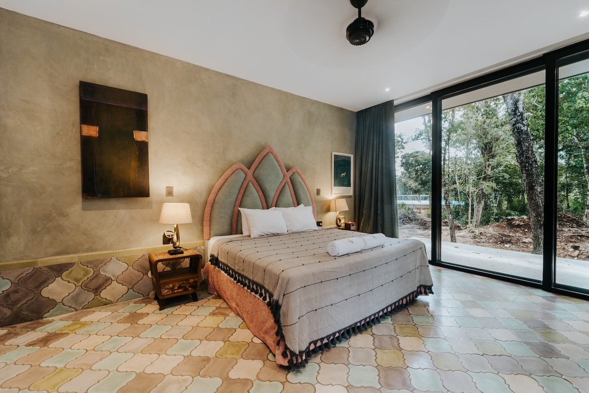 Artful and serene, this unique suite features handcrafted tile floors, arched design accents, and floor-to-ceiling views of the jungle—perfect for restful, inspired stays.
