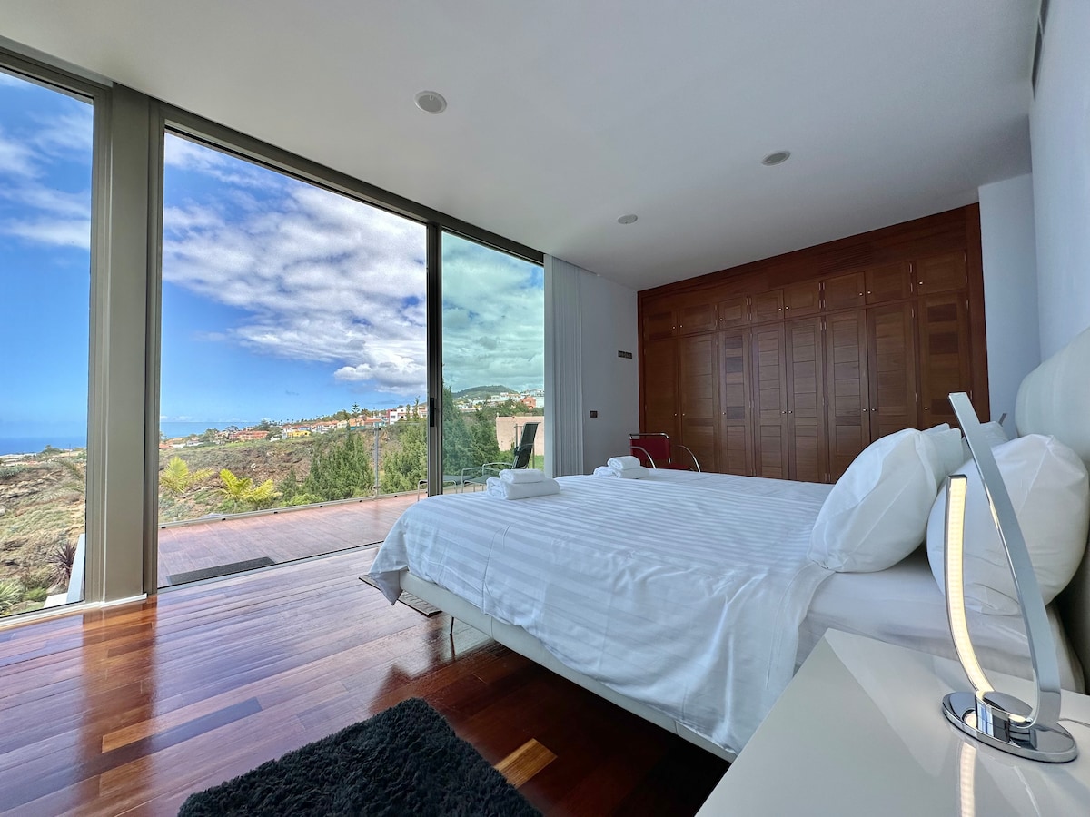 главната спалня има балкон/тераса с изглед към океана и планината и шезлонги 