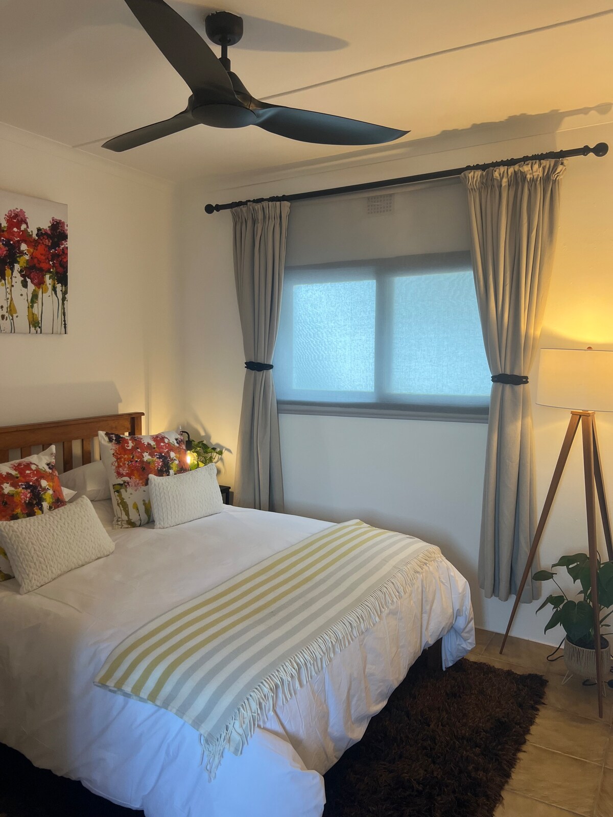 Ეს მშვიდი საძინებელი აერთიანებს კომფორტსა და სანაპირო ხიბლს დედოფლის საწოლთან, ხრაშუნა თეთრეულთან, მაცოცხლებელ ბალიშებთან და რბილ ისრებთან. Ღია თარო, პირსახოცის კიბე და ფოთლოვანი მცენარე პრაქტიკულ ელეგანტურობას ანიჭებს, რბილი განათება და ხელოვნების ნიმუშები კი მყუდრო, მშვიდ გარემოს ქმნის.