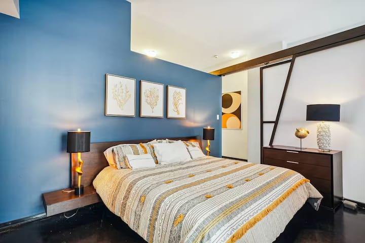 Udobna i elegantna spavaća soba s bračnim krevetom, smelim ukrasnim zidom i blagim osvjetljenjem. Klizne ploče pružaju privatnost, a istovremeno održavaju osjećaj otvorenosti u prostoru. Savršeno za ugodne noći u modernom, pažljivo uređenom prostoru.