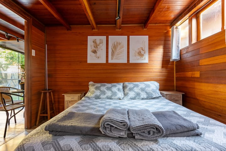 Habitación cómoda en el piso inferior con luz natural, cortinas opacas, cómodas y un juego completo de sábanas.