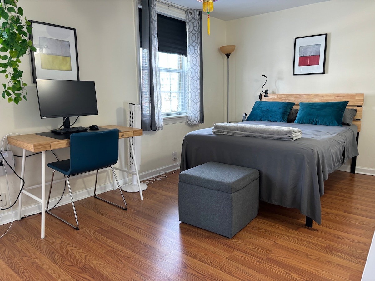 Sovrum med bekväm säng i full storlek, skrivbord och Mac ansluten till en 24" extern bildskärm som också kan användas för att ansluta till din bärbara dator.