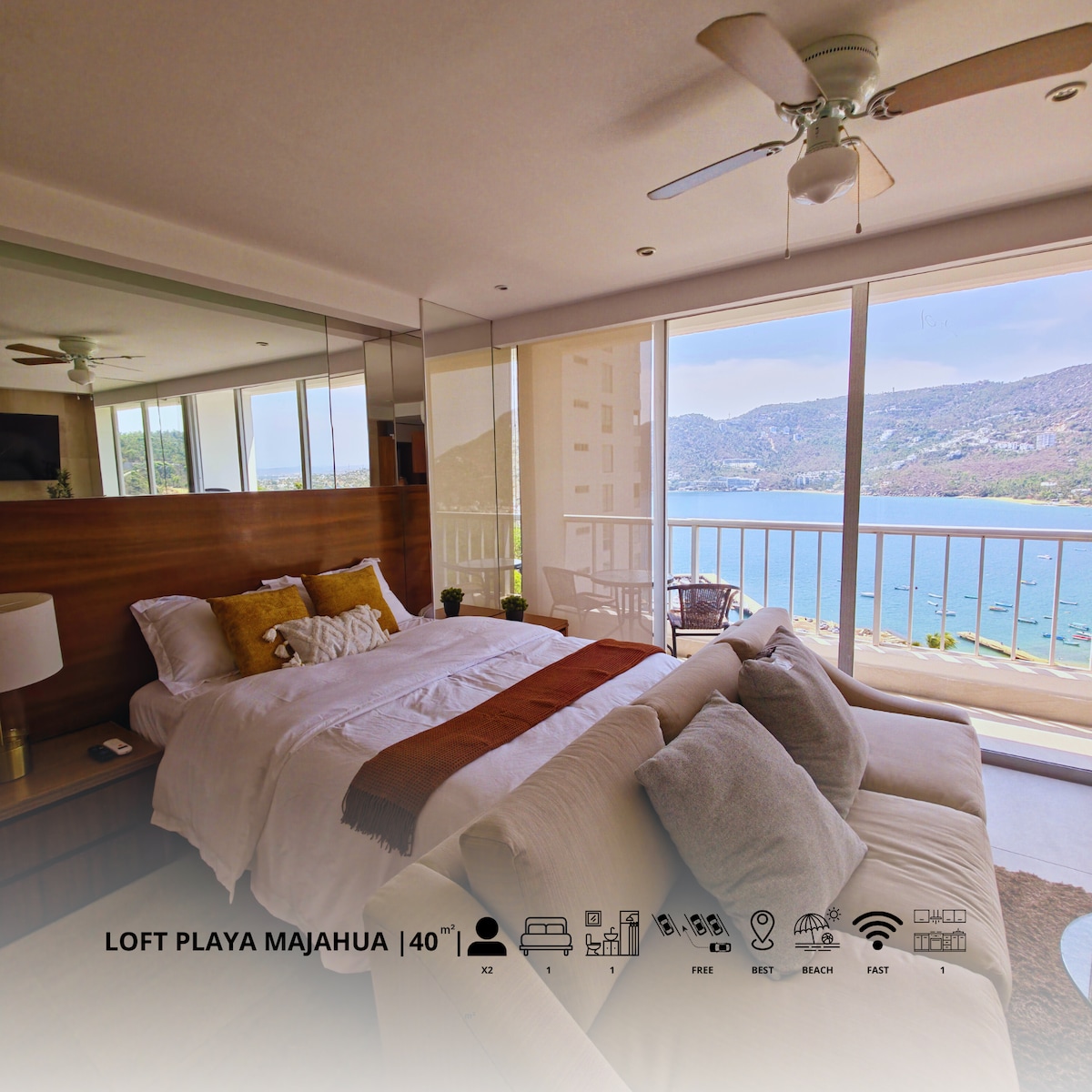 A spacious bedroom features a comfortable bed with crisp linens, offering views through large glass doors that open to a balcony overlooking the ocean. Natural light fills the room, enhancing the tranquil atmosphere. A cozy seating area is positioned next to the window.