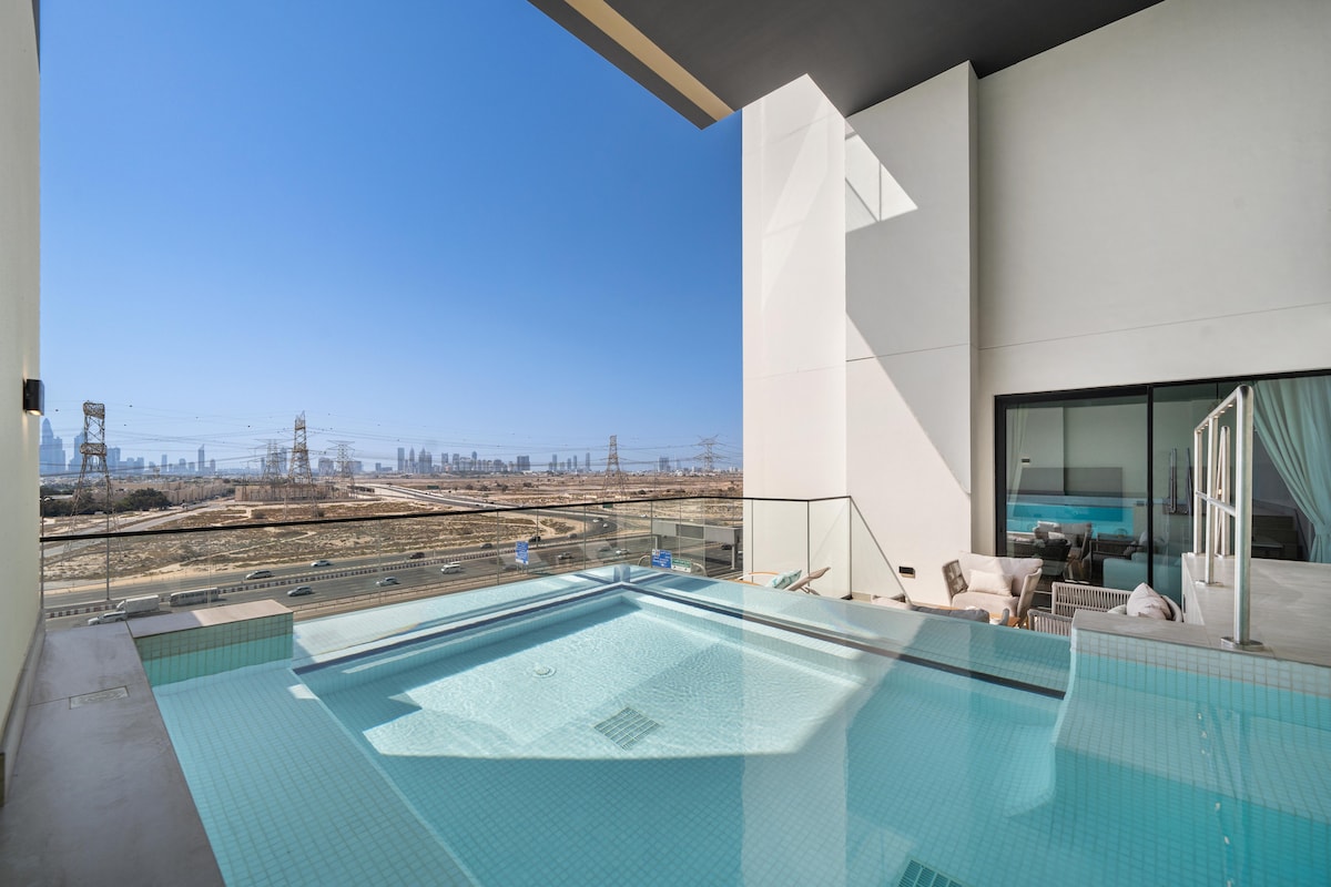 A private swimming pool is visible, featuring clear water and modern tile work. Glass railings provide unobstructed views of the skyline, with a spacious outdoor seating area nearby. The sunlit area showcases a clean design, blending relaxation with an inviting atmosphere.