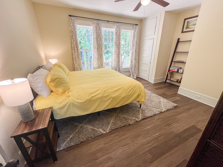 The main bedroom features a king bed, two closets, and shelves stocked with board games and books.