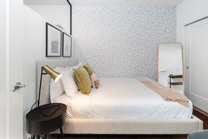 安静的卧室，配有一张标准双人床、大胆的特色墙和柔和的照明，让您享受宁静的夜晚睡眠。